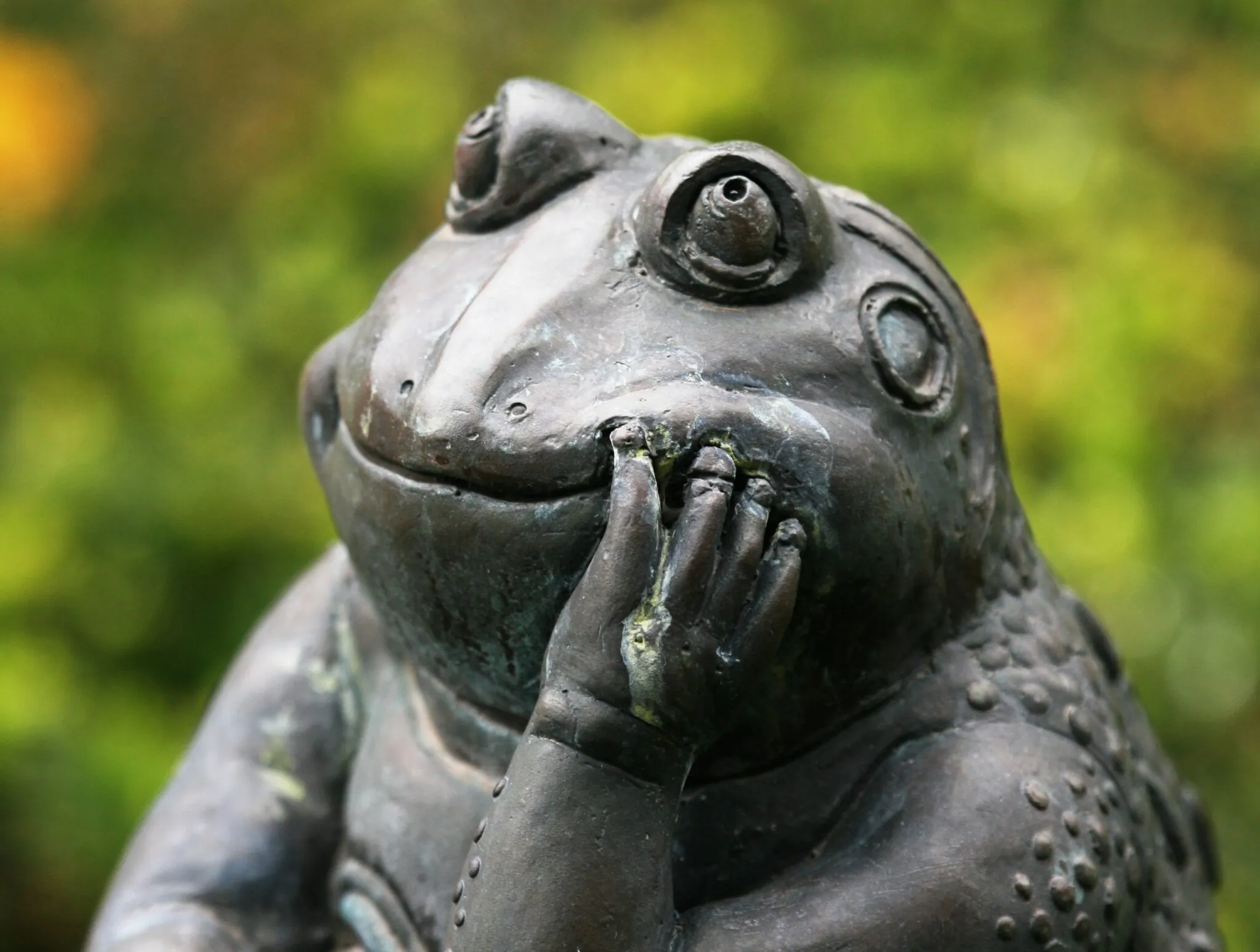 statue of pondering frog with hand on chin