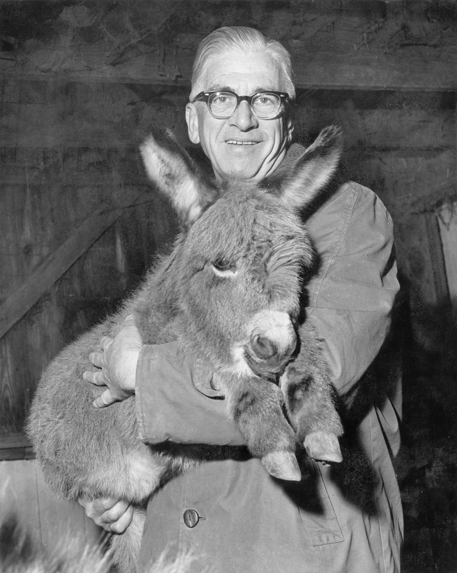 black and white photo of Lowell Nussbaum holding donkey