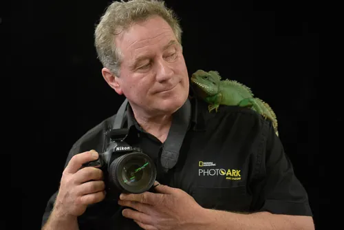 Joel Sartore wildlife photographer with camera and chameleon on shoulder