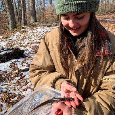 woman in brown coat holding salamander