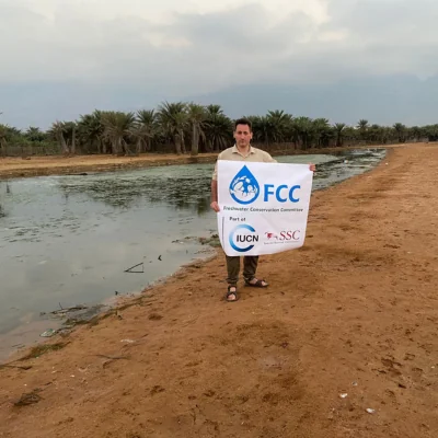 man standing with sign at lagoon