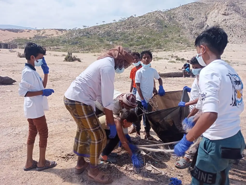 group of kids cleaning the beach in Detwah