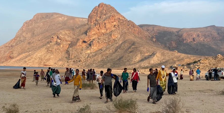 large group cleaning weltands area near mountains
