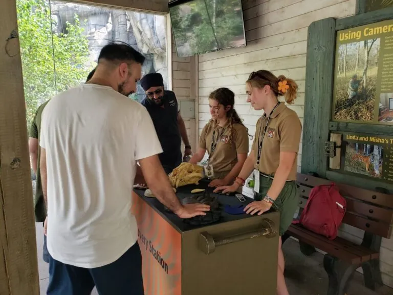 Two teen volunteers show guests an animal skull.
