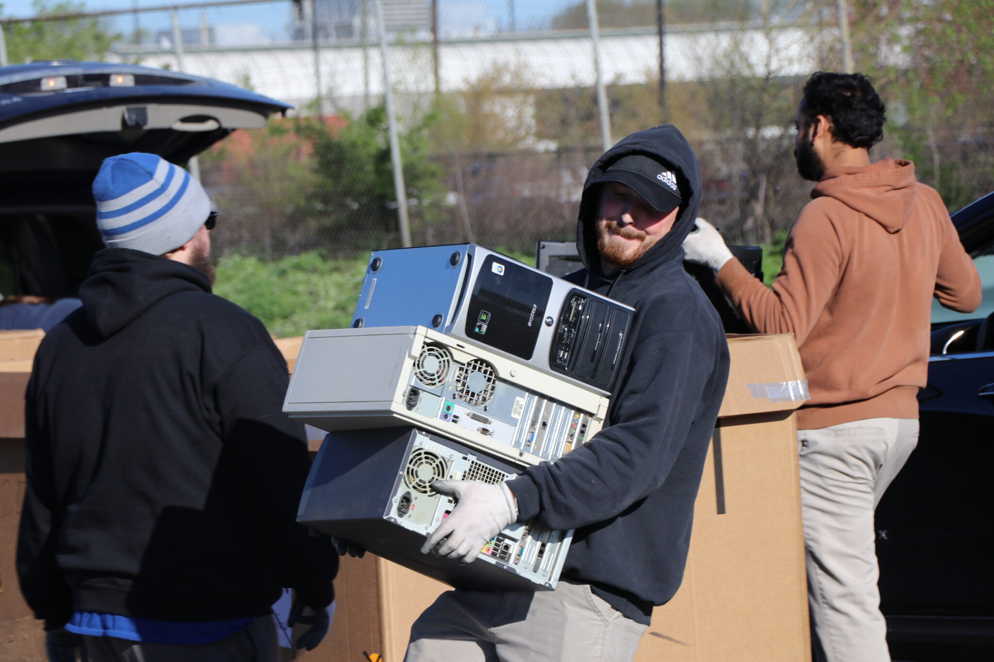 man carrying old computer towers for recycling