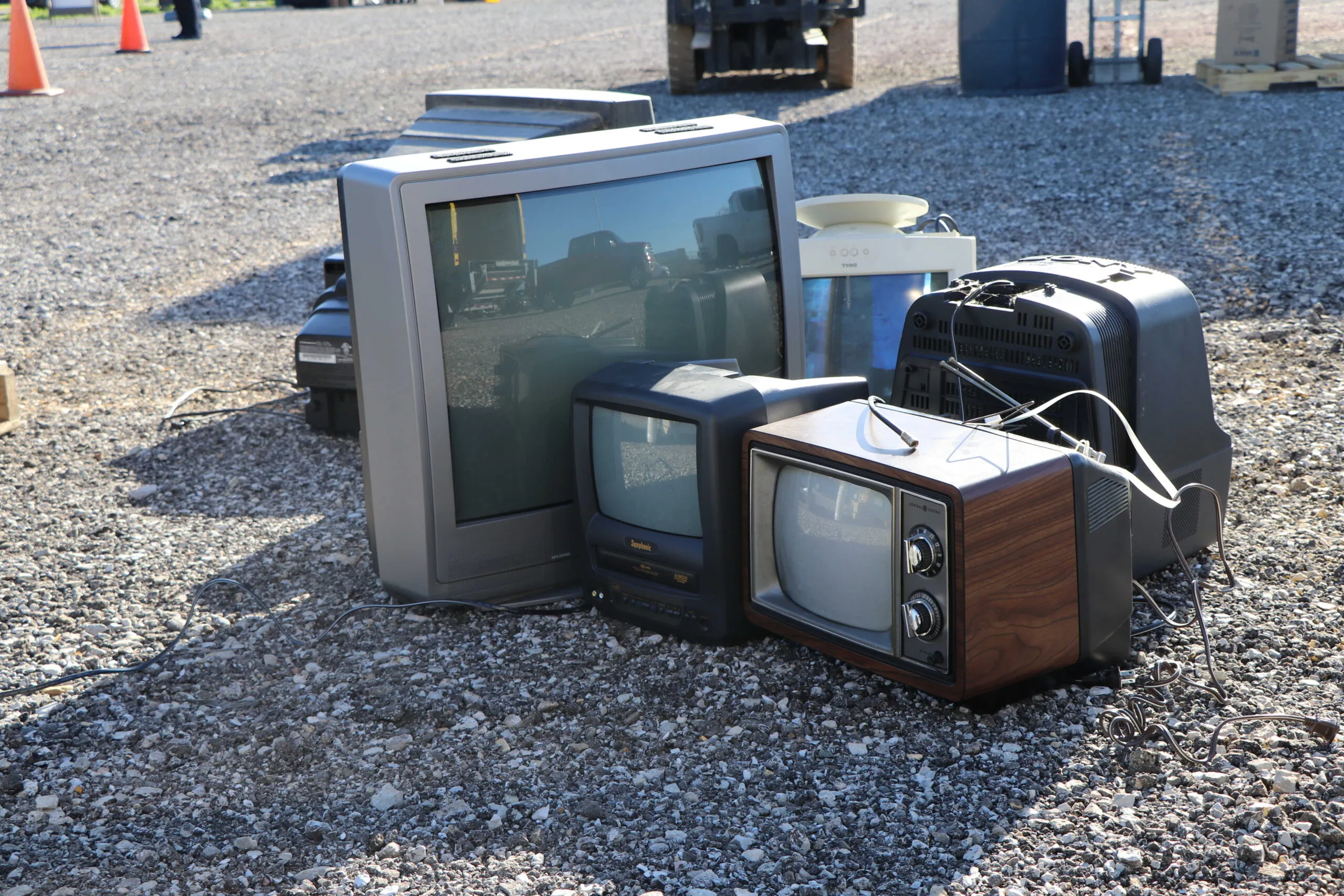 old televisions sitting in parking lot