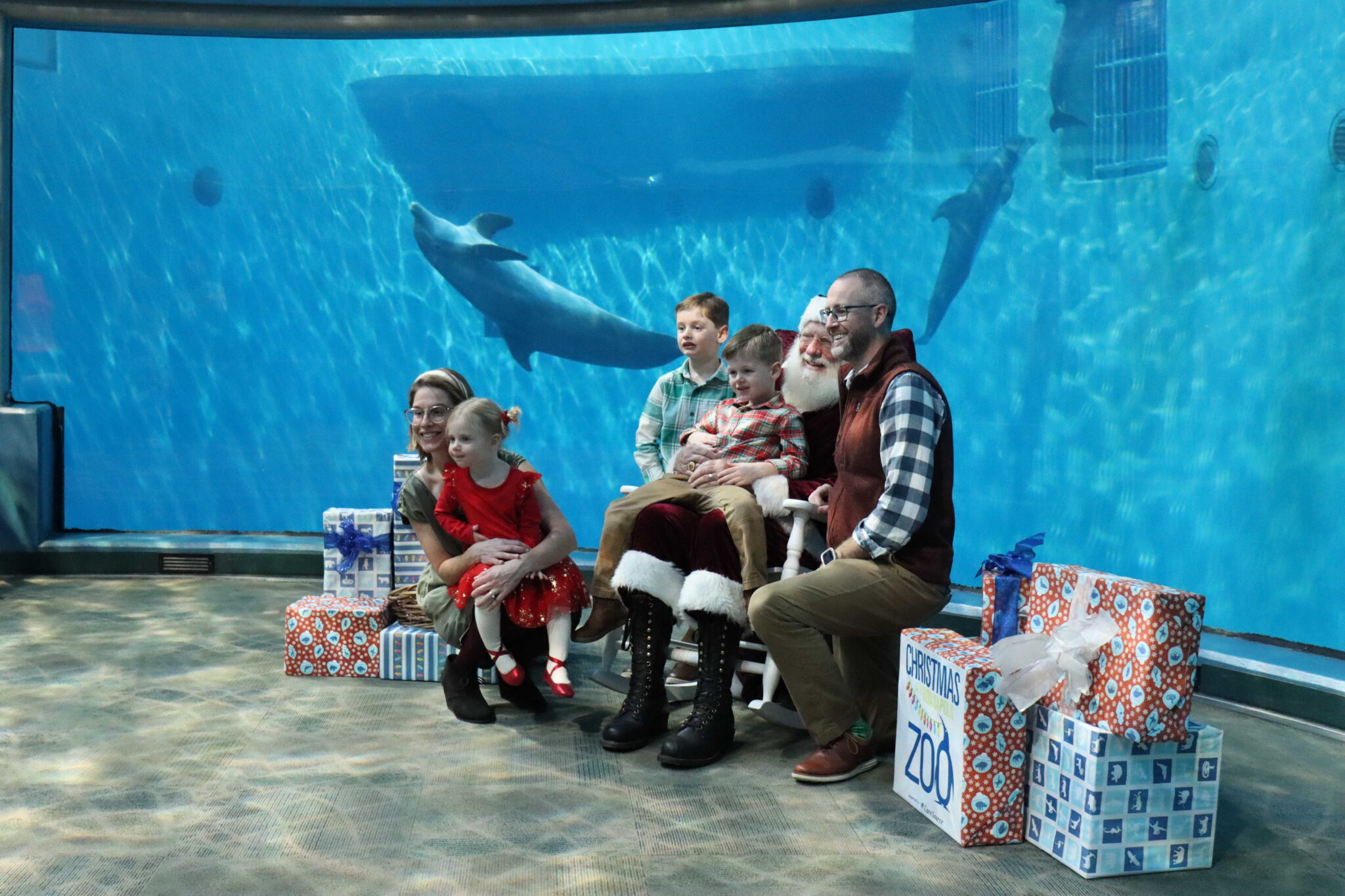 family taking photos with Santa at the Indianapolis Zoo Dolphin Gallery