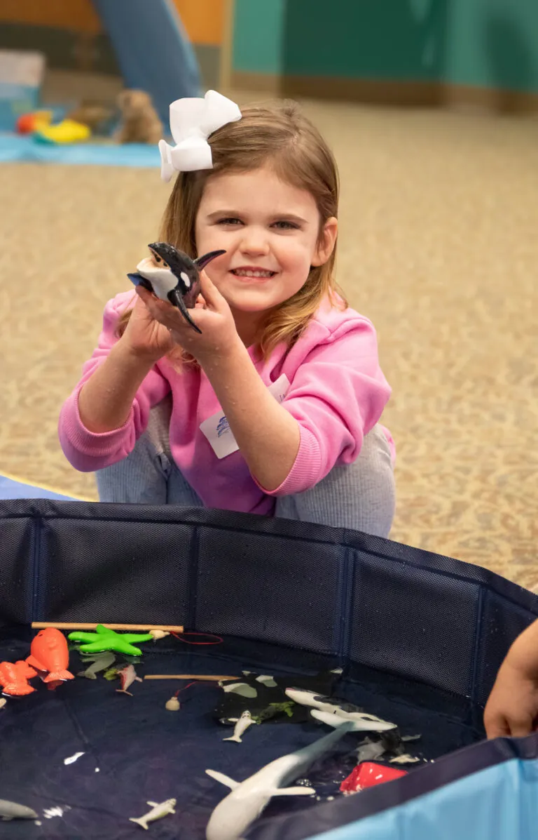 little girl with orca toy