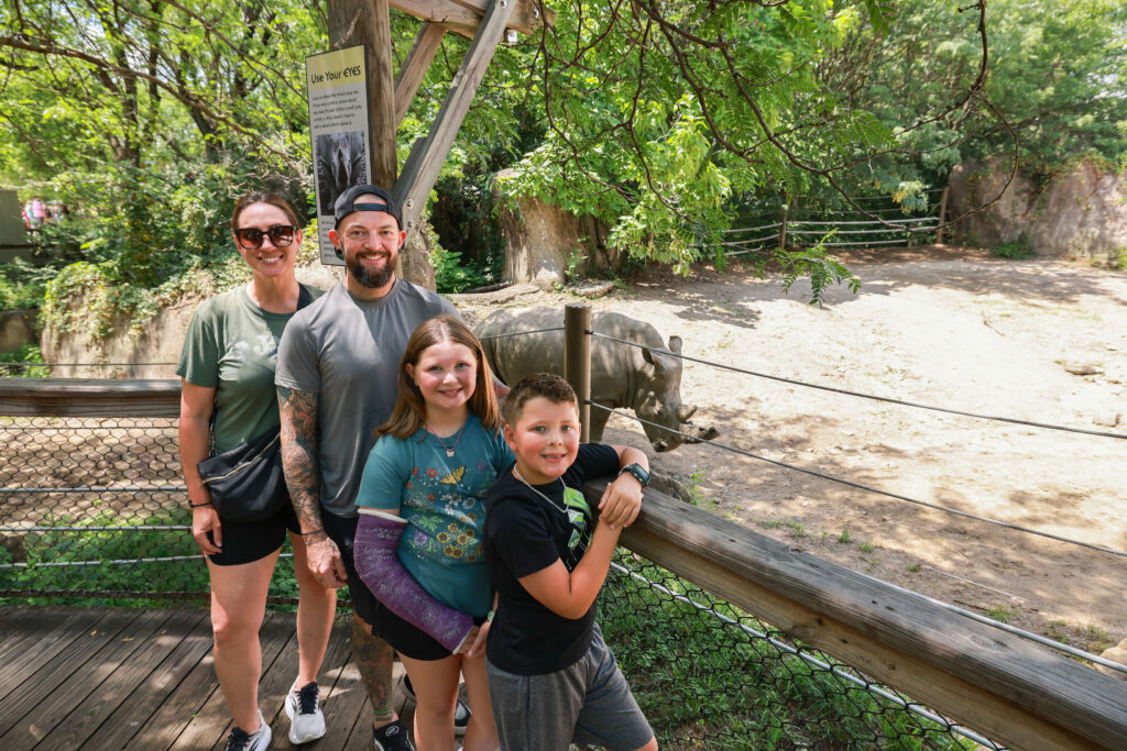 family photo with rhino in background