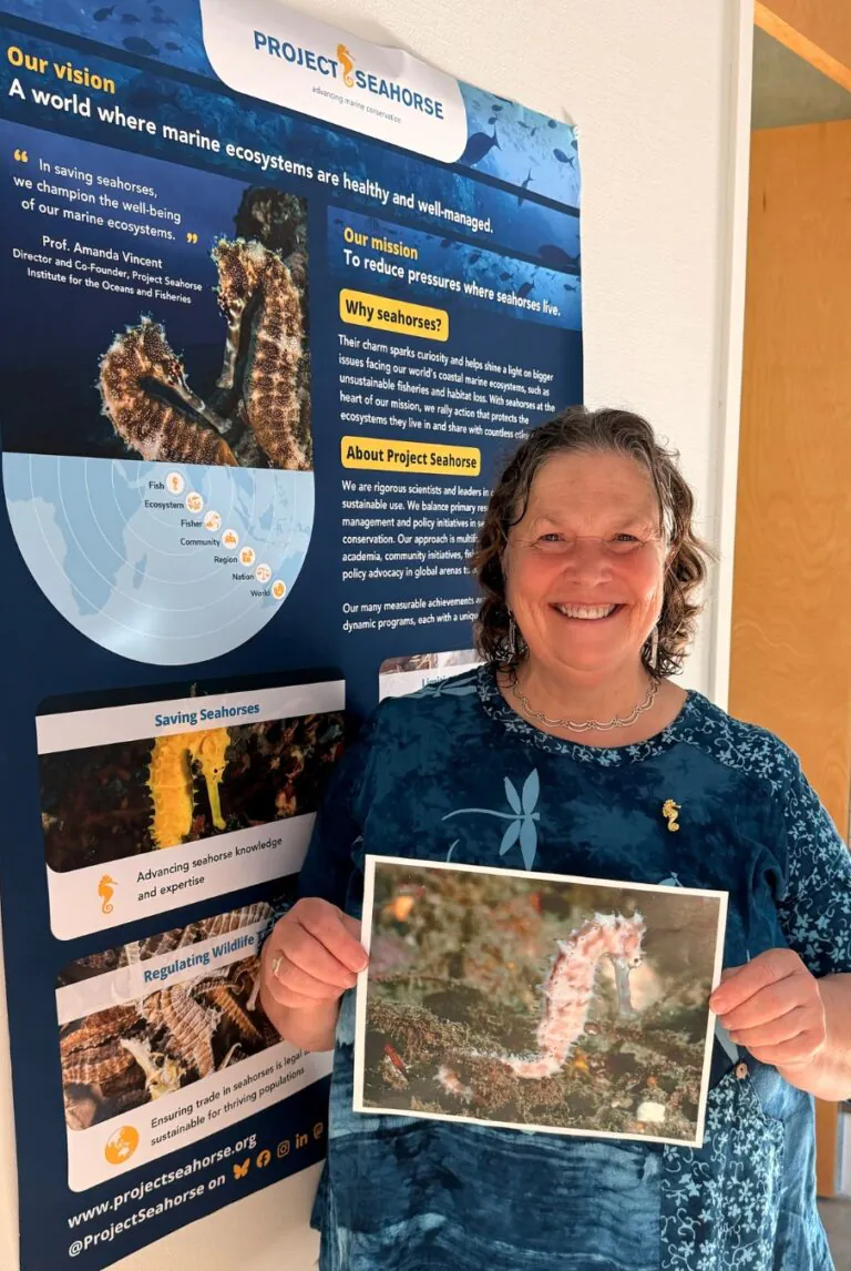 woman holding photo of seahorse