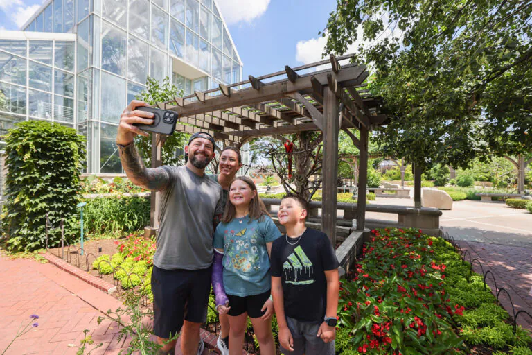 family taking a selfie in front of a macaw